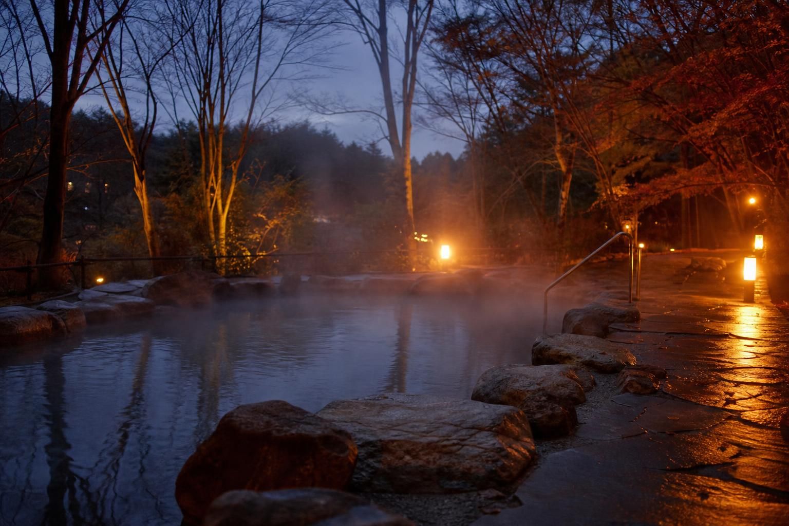 Dampfendes Außenbecken einer Therme am Abend