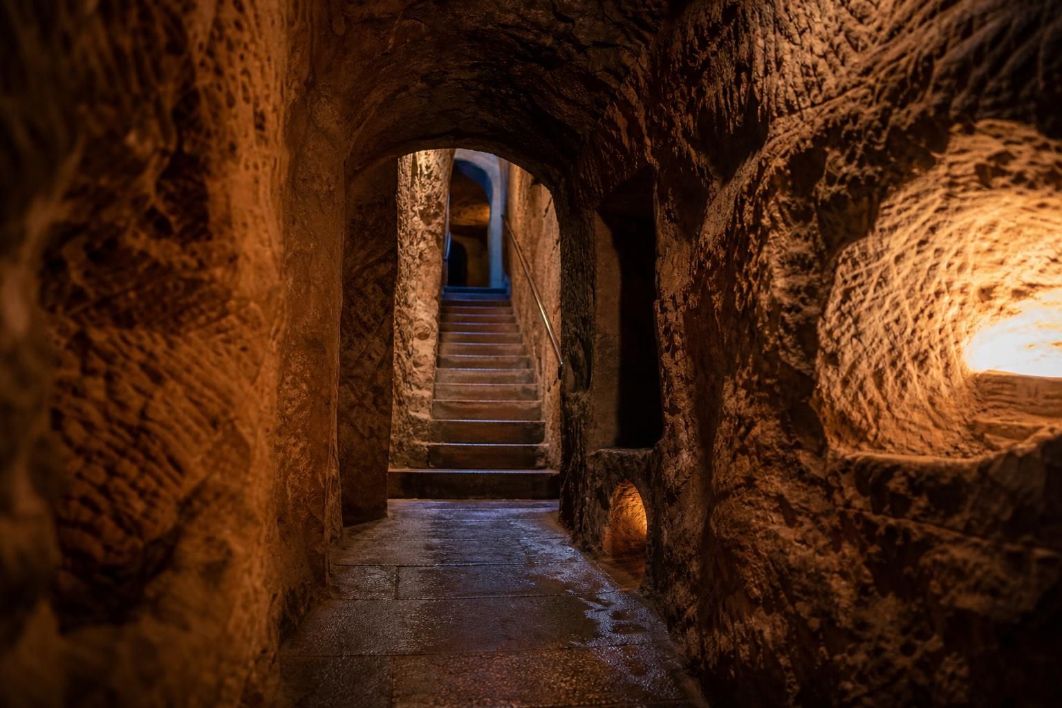 Historische Felsengänge mit kühlen Sandsteinmauern und Treppen